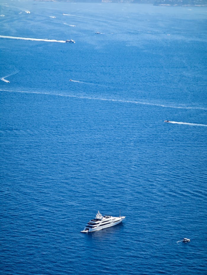 Aerial view of a luxury yacht cruising the blue waters near Capri, Italy.