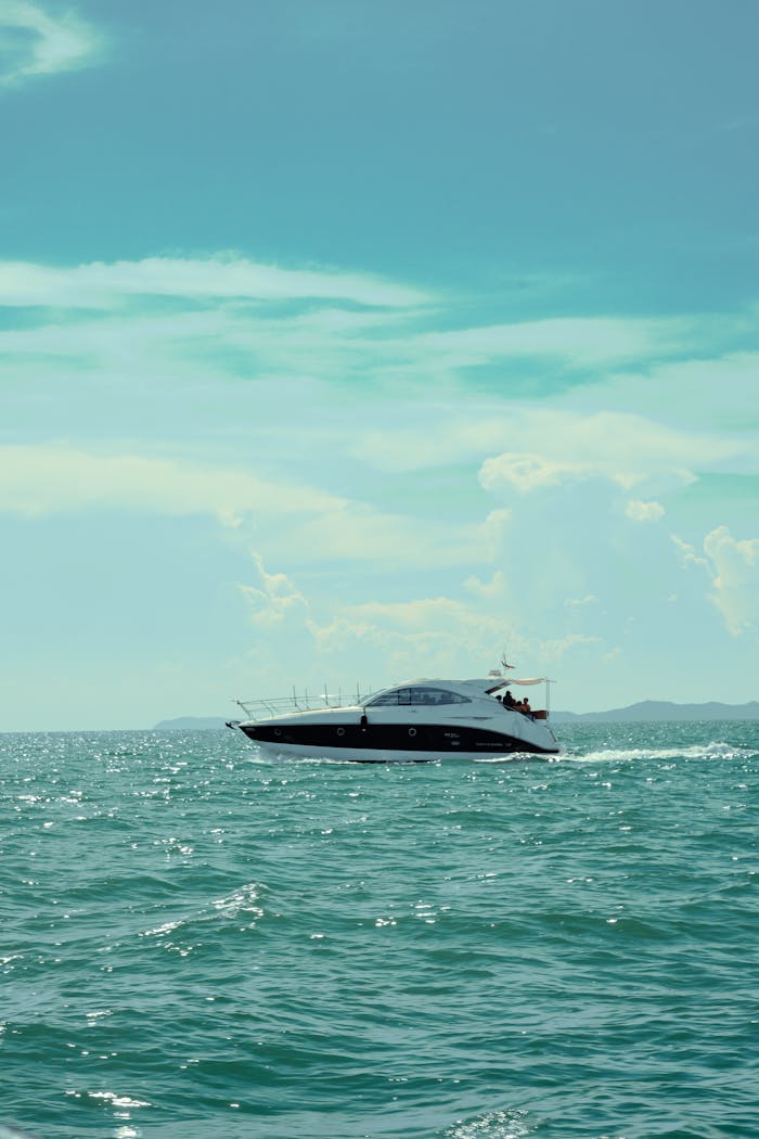 Elegant yacht sailing through pristine ocean under clear blue skies.