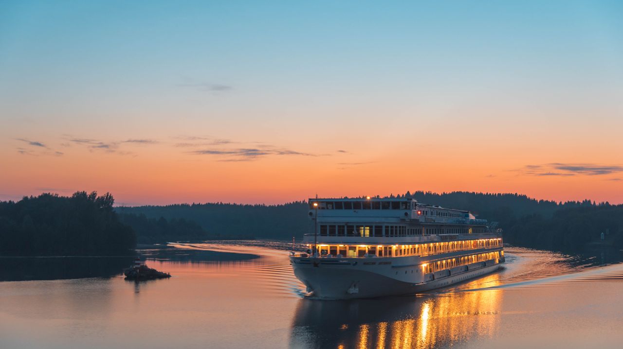 Elegant cruise ship gliding along Lake Ladoga at sunset, reflecting the serene beauty of Russian landscapes.